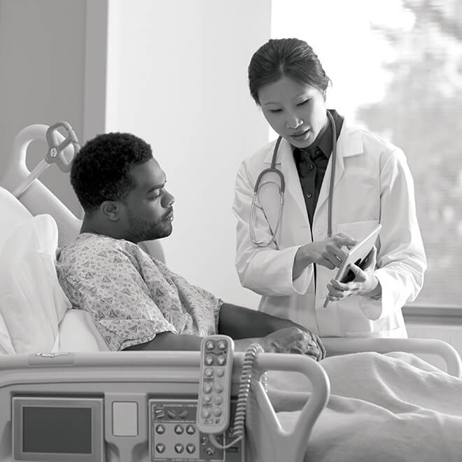 Clinician at patient bedside with tablet