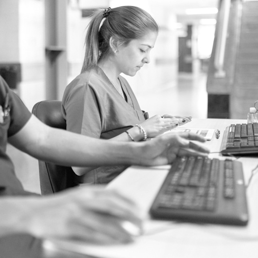 Female clinician sitting at computer keyboard